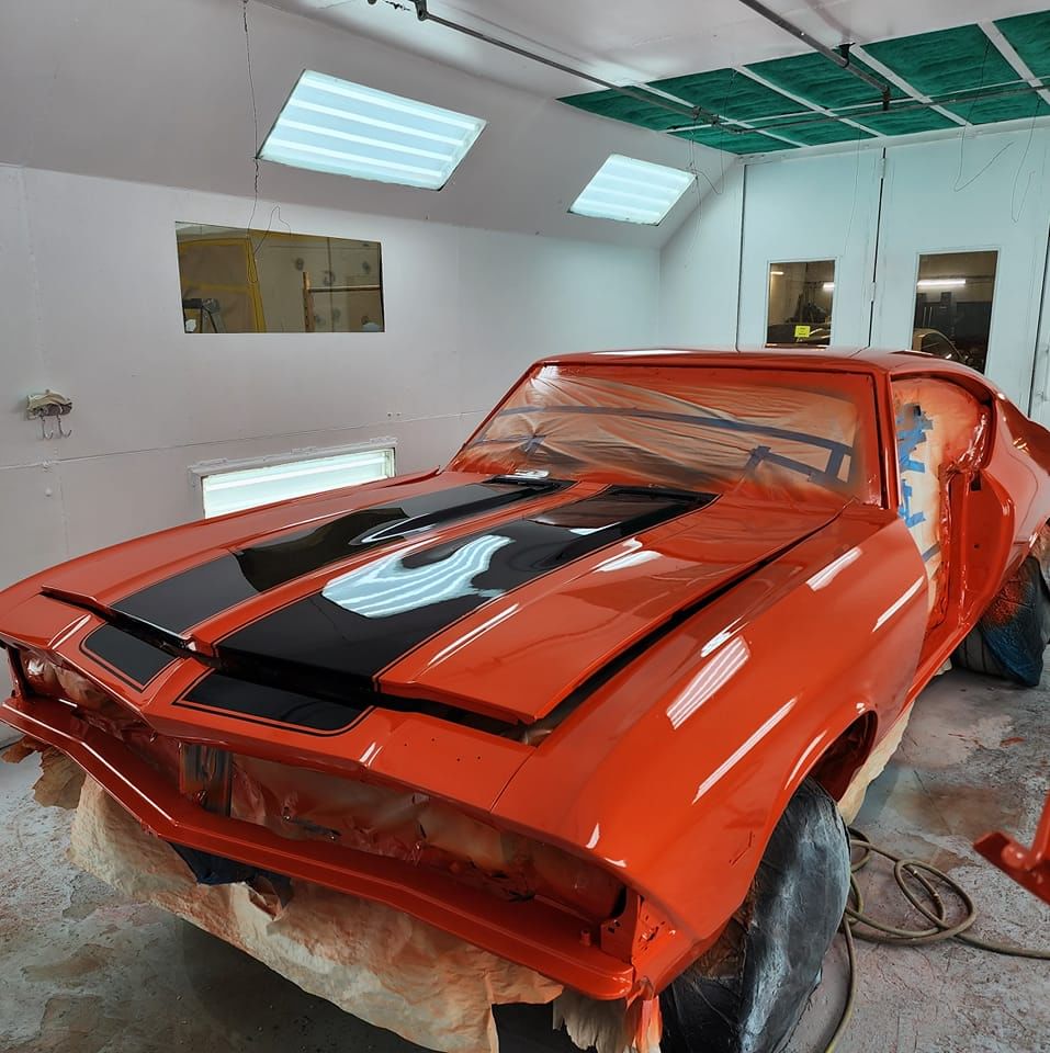  Carrossier ponçant un panneau de carrosserie dans un atelier à Brownsburg-Chattam 