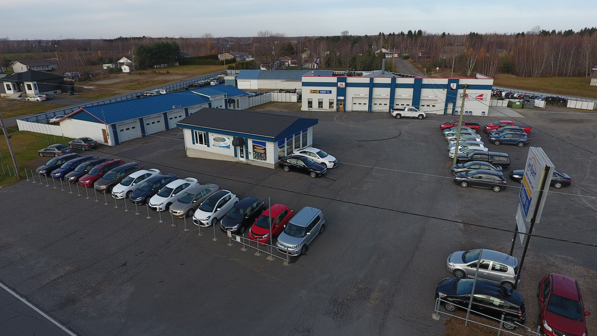  Carrossier ponçant un panneau de carrosserie dans un atelier à Plessisville 