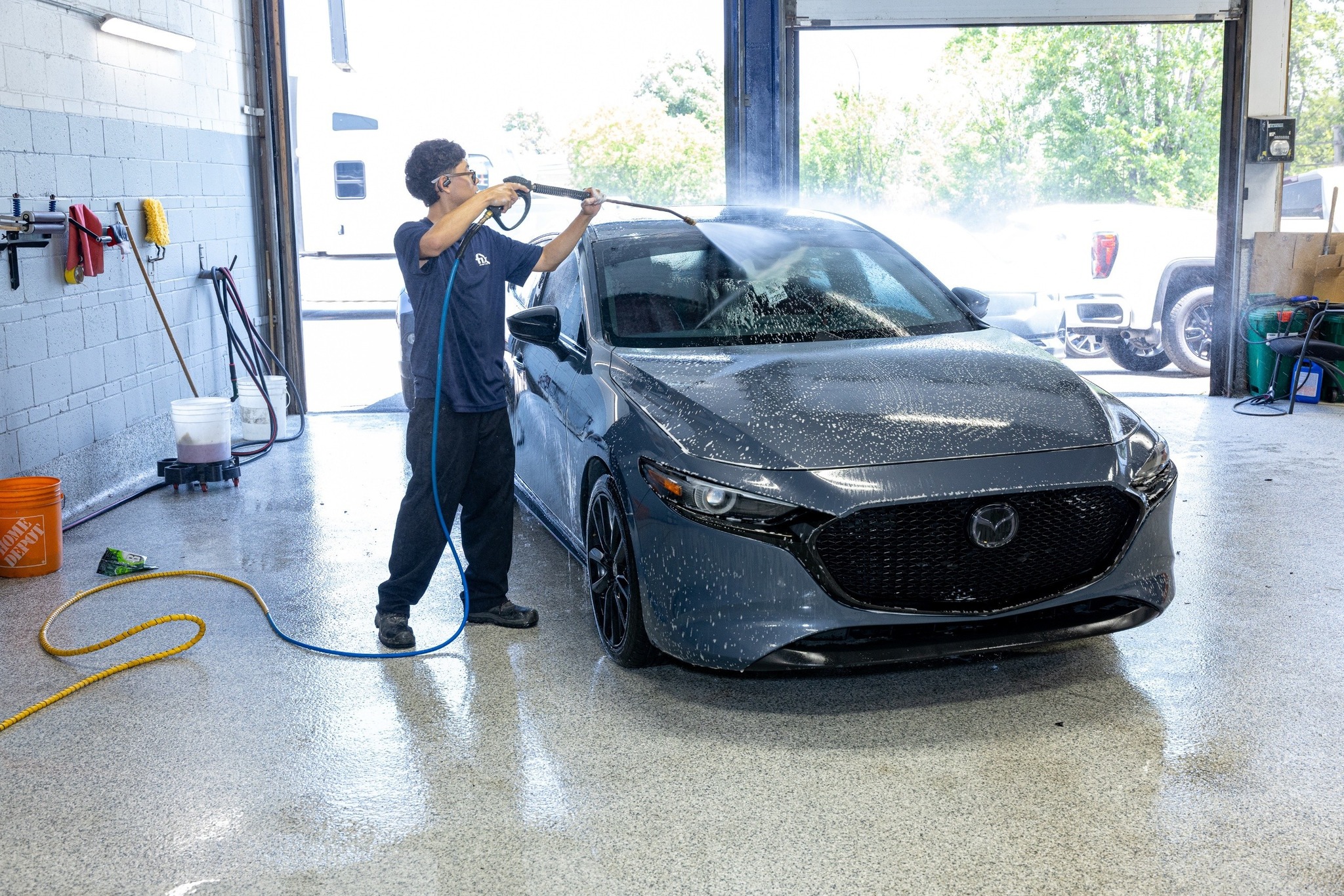 Panneaux et pare‑chocs en attente de réparation dans un atelier de carrosserie à Saint-Georges