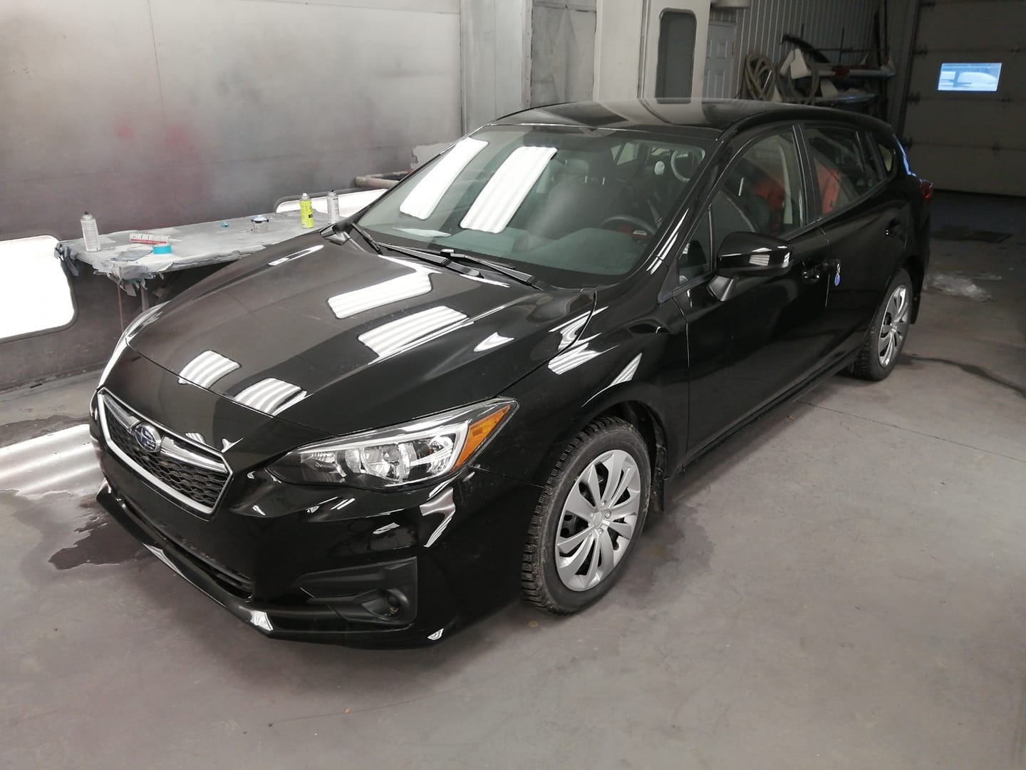 Panneaux et pare‑chocs en attente de réparation dans un atelier de carrosserie à Thetford-Mines