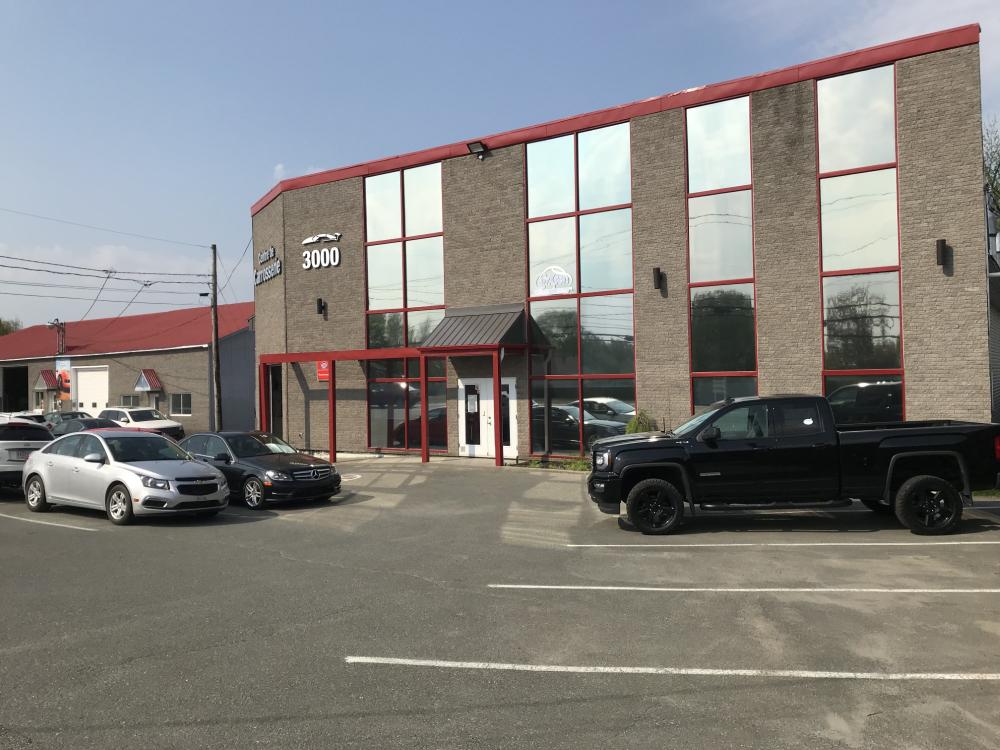  Carrossier ponçant un panneau de carrosserie dans un atelier dans Bellechasse 